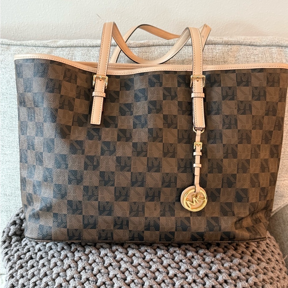 MICHAEL Michael Kors Jet Set travel tote in a brown checkered monogram pattern.